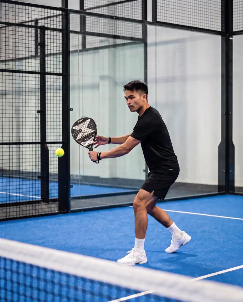 Joshua Olberg auf dem Padelcourt, Rückhand am Netz, mit KI erstellt